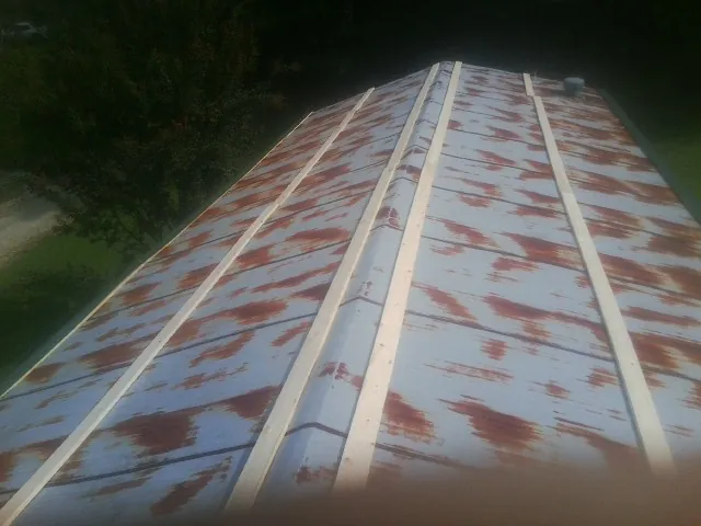 Rusted metal roof panels with new wood purlins before replacement — Storm Damage Roof Repair in Harmony by Roofing Brothers